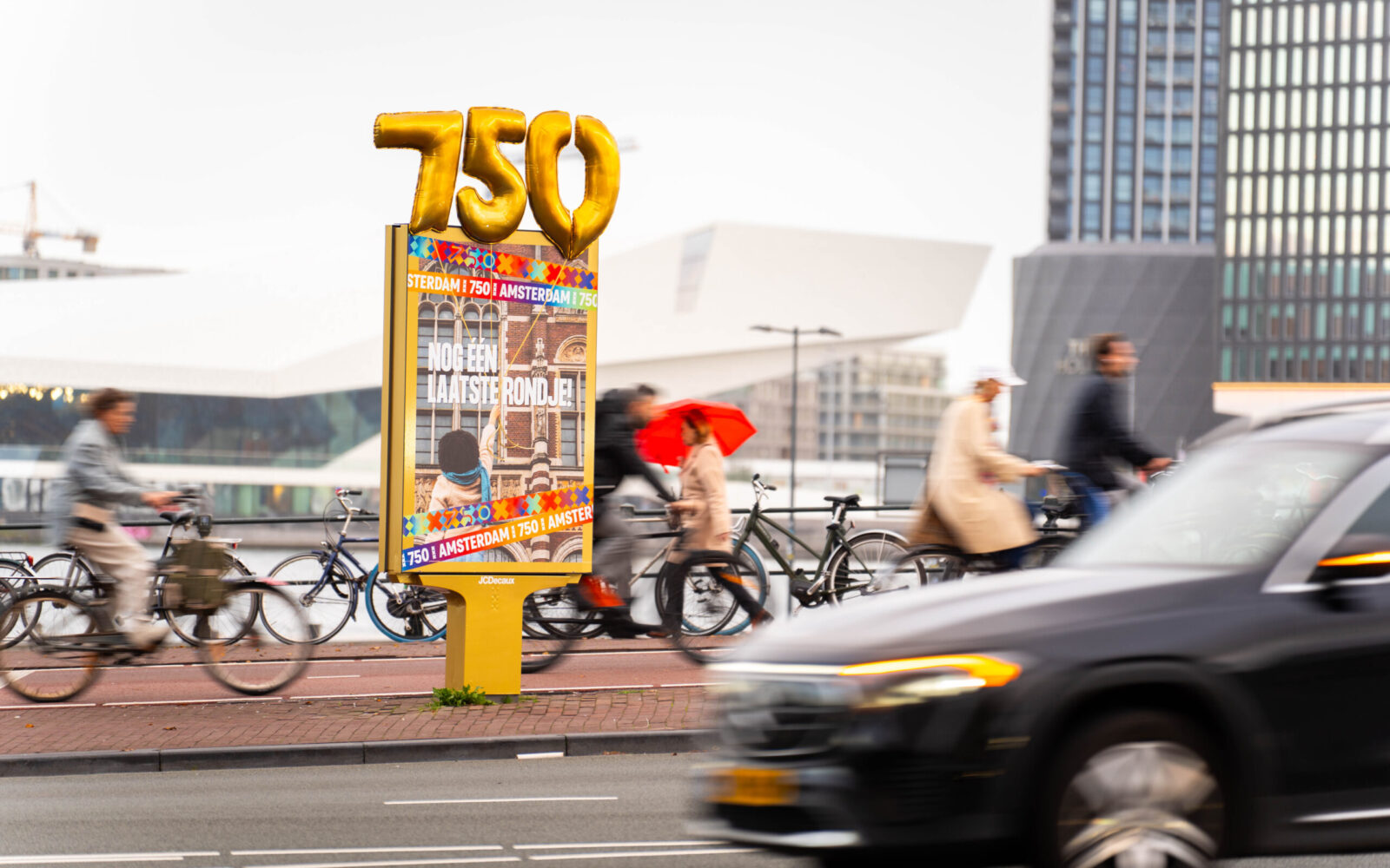 Grote gouden ballonnen en meterslange slingers kleden Amsterdam aan tijdens feestelijke afsluiting jubileumjaar